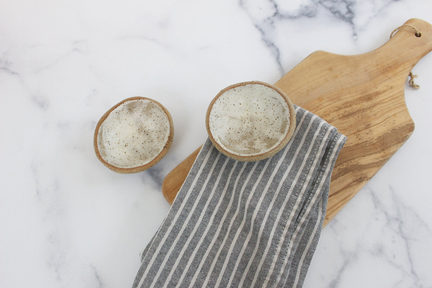 two little bowls on a wooden cutting board