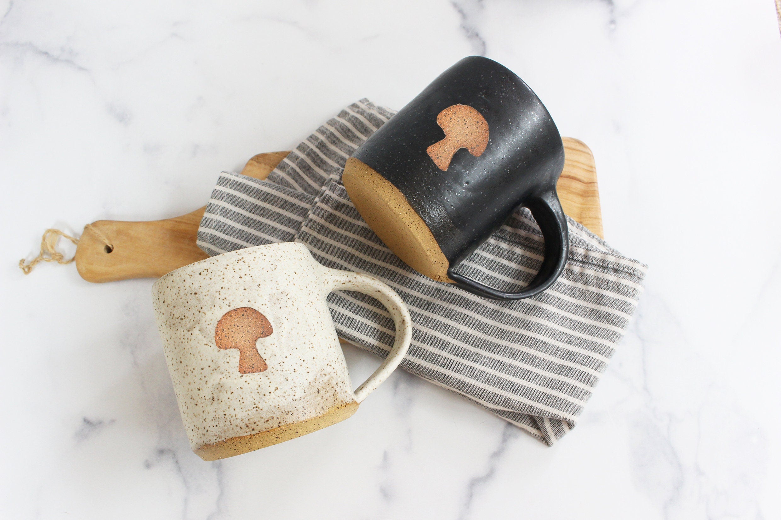 two minimal handmade mushroom mugs on a kitchen counter